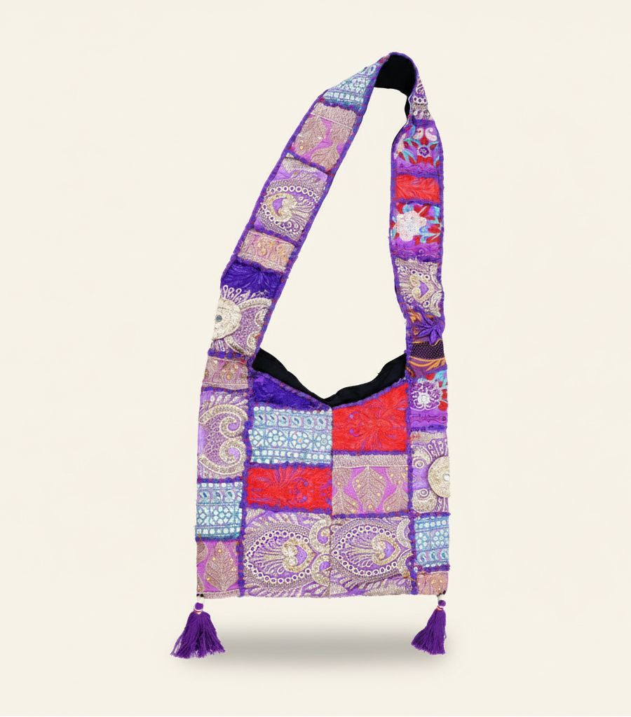 Purplepatchwork bag with a patterned strap on a white background