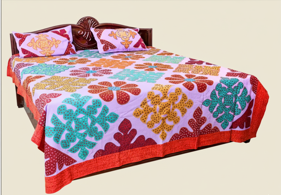 Colorful floral-patterned bedspread on a bed with matching pillows.