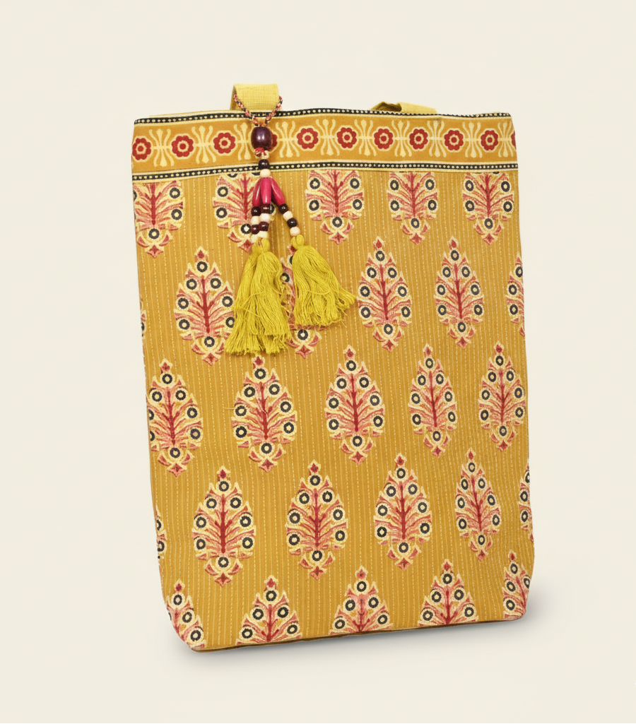 Yellow patterned bag with tassel on a beige background