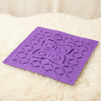 Purple decorative table napkin with floral patterns on a beige surface
