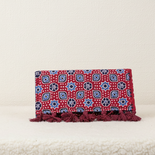 Red and blue patterned clutch bag with tassels on a white background