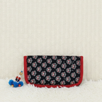 Floral patterned pouch with red border on a textured surface