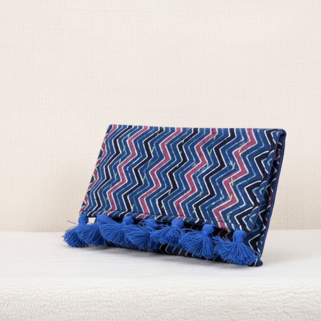 Decorative blue purse with zigzag pattern and tassels on a white background