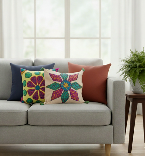 Gray sofa with colorful patterned applique cushions in a bright living room.