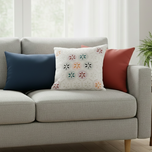 Gray sofa with applique work white cushion in a living room setting