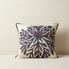 Decorative pillow with a blue and red pattern on a neutral background