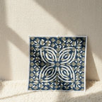 Decorative blue and gold patterned napkin on a textured surface