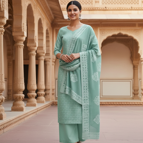 Woman in a blue applique suit set with cutwork design standing in an ornate architectural setting