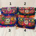 Colorful embroidered boho bags with floral patterns on a textured surface