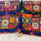 Colorful embroidered bags with floral and geometric patterns on a white surface
