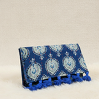 Blue patterned clutch with tassels on a beige background