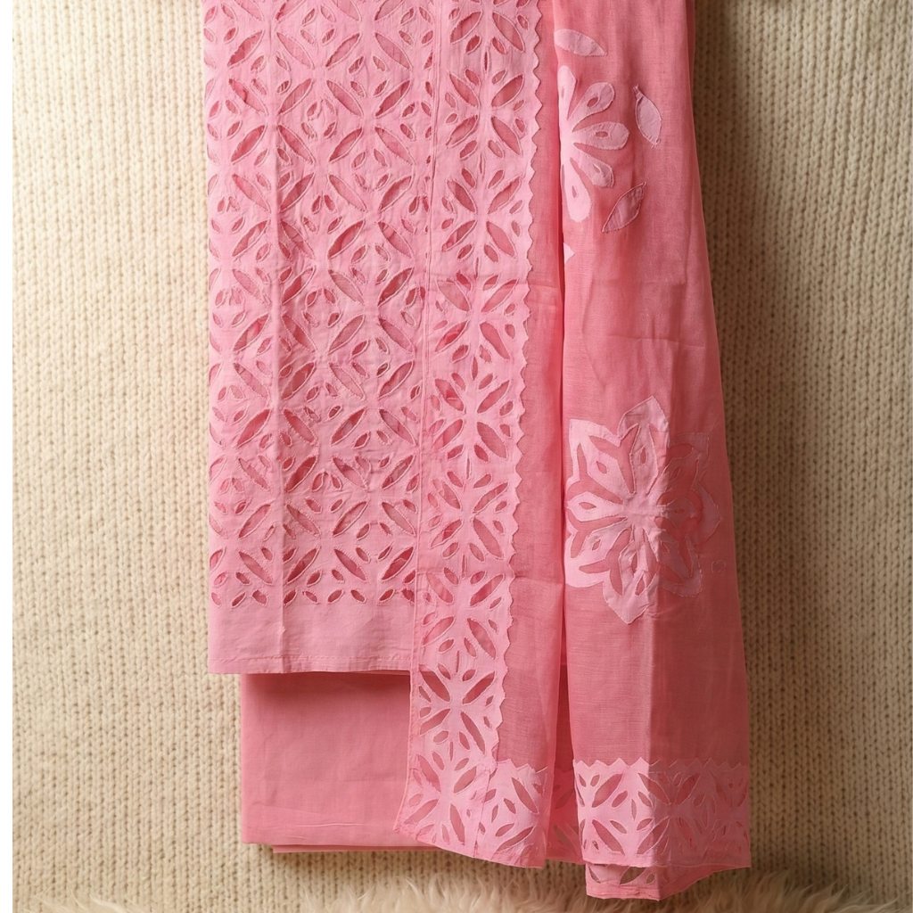 Pink embroidered fabric on a beige surface