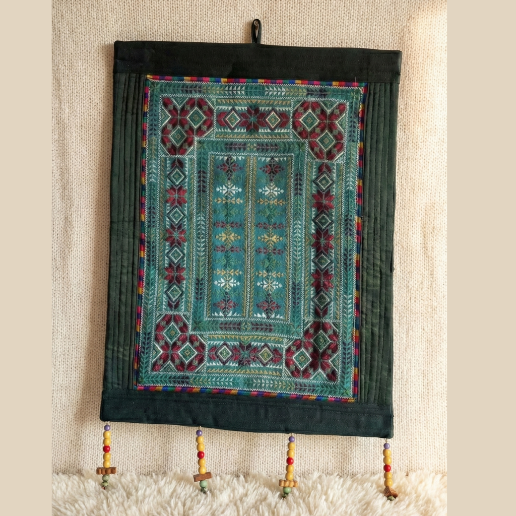 Decorative wall hanging with intricate patterns on a textured wall.