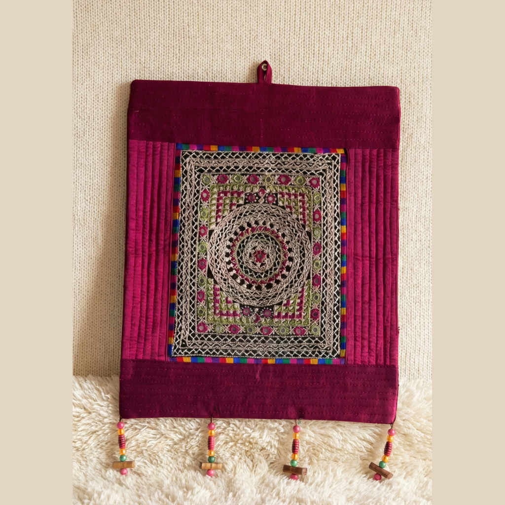 Decorative wall hanging with intricate patterns on a textured surface