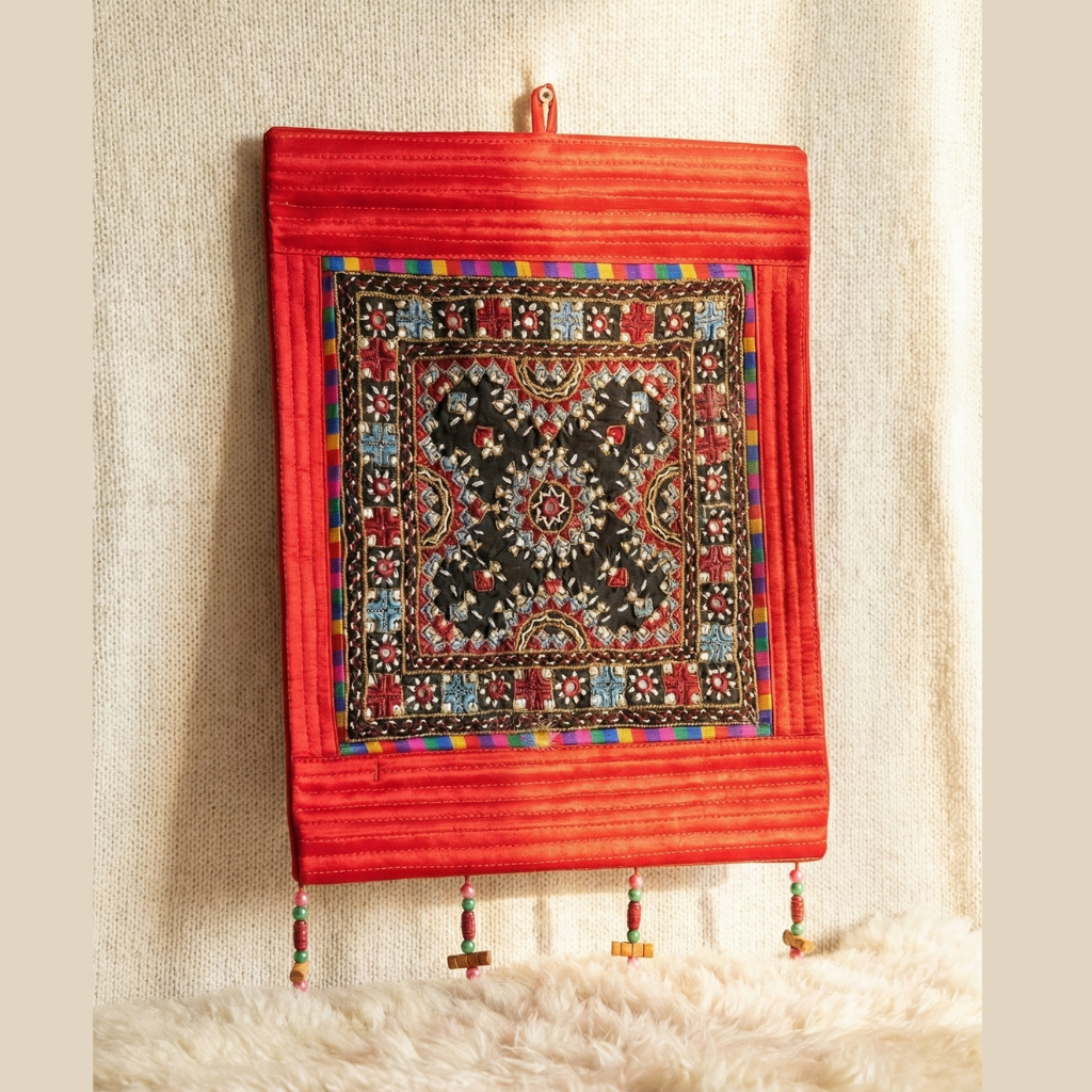 Decorative wall hanging with intricate patterns on a red background