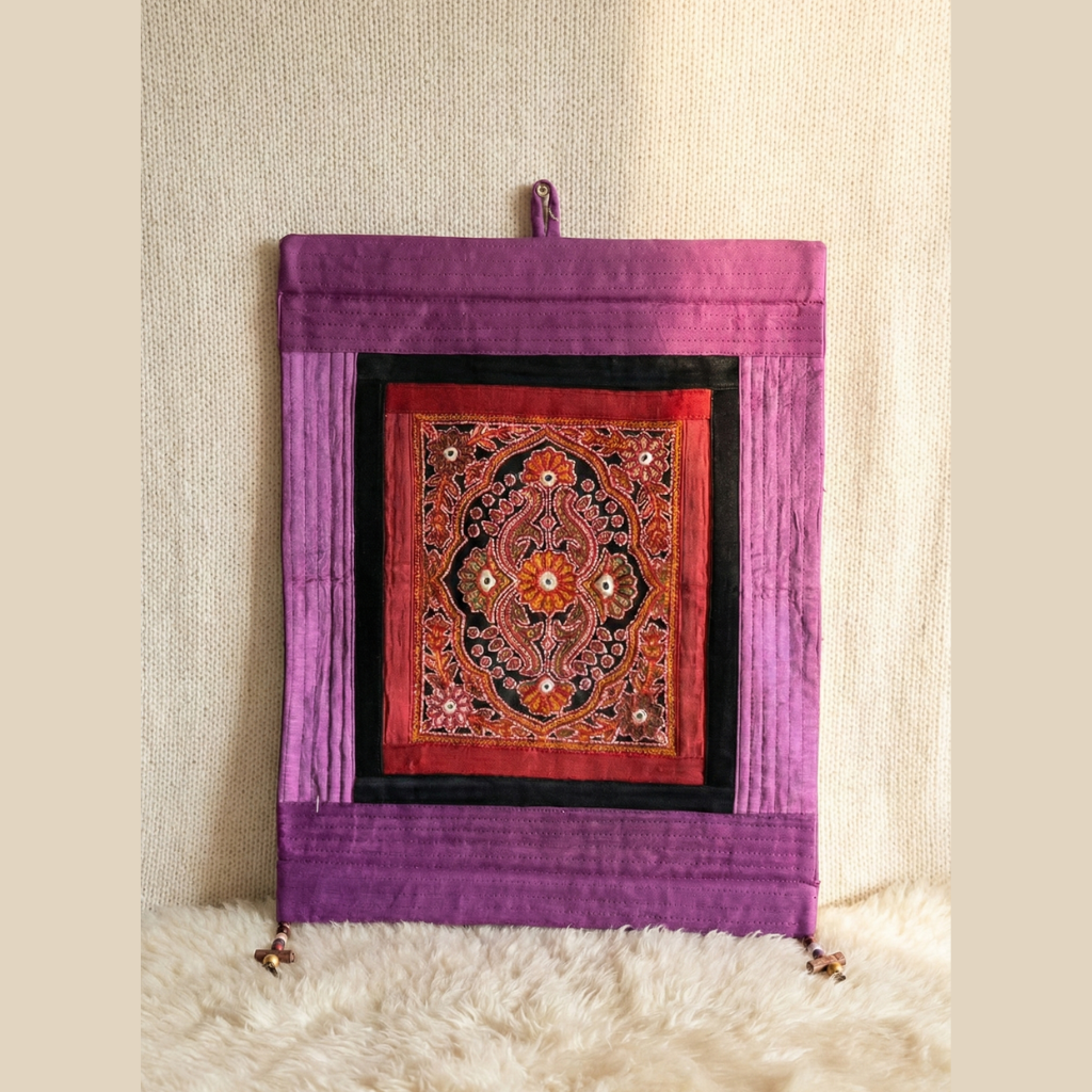 Decorative wall hanging with intricate design on a purple background