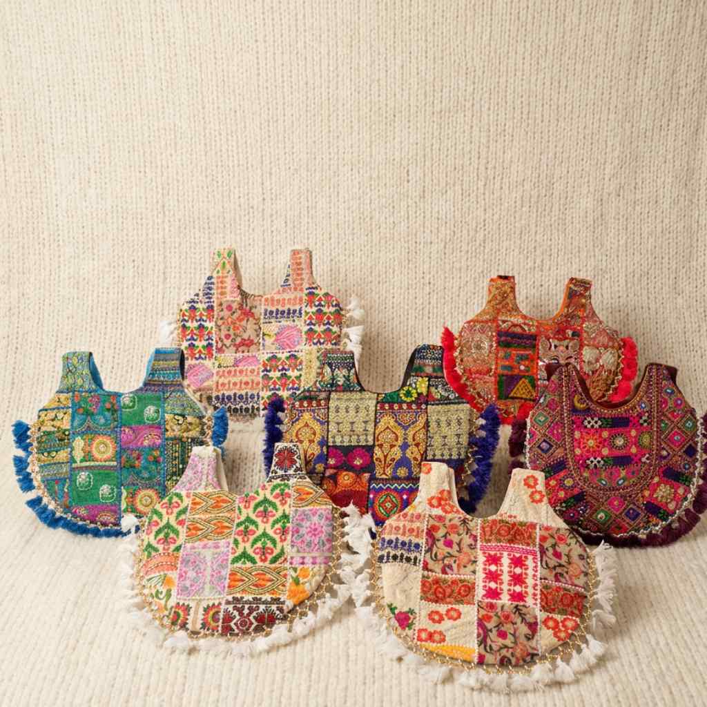 Collection of colorful embroidered bags on a textured beige background