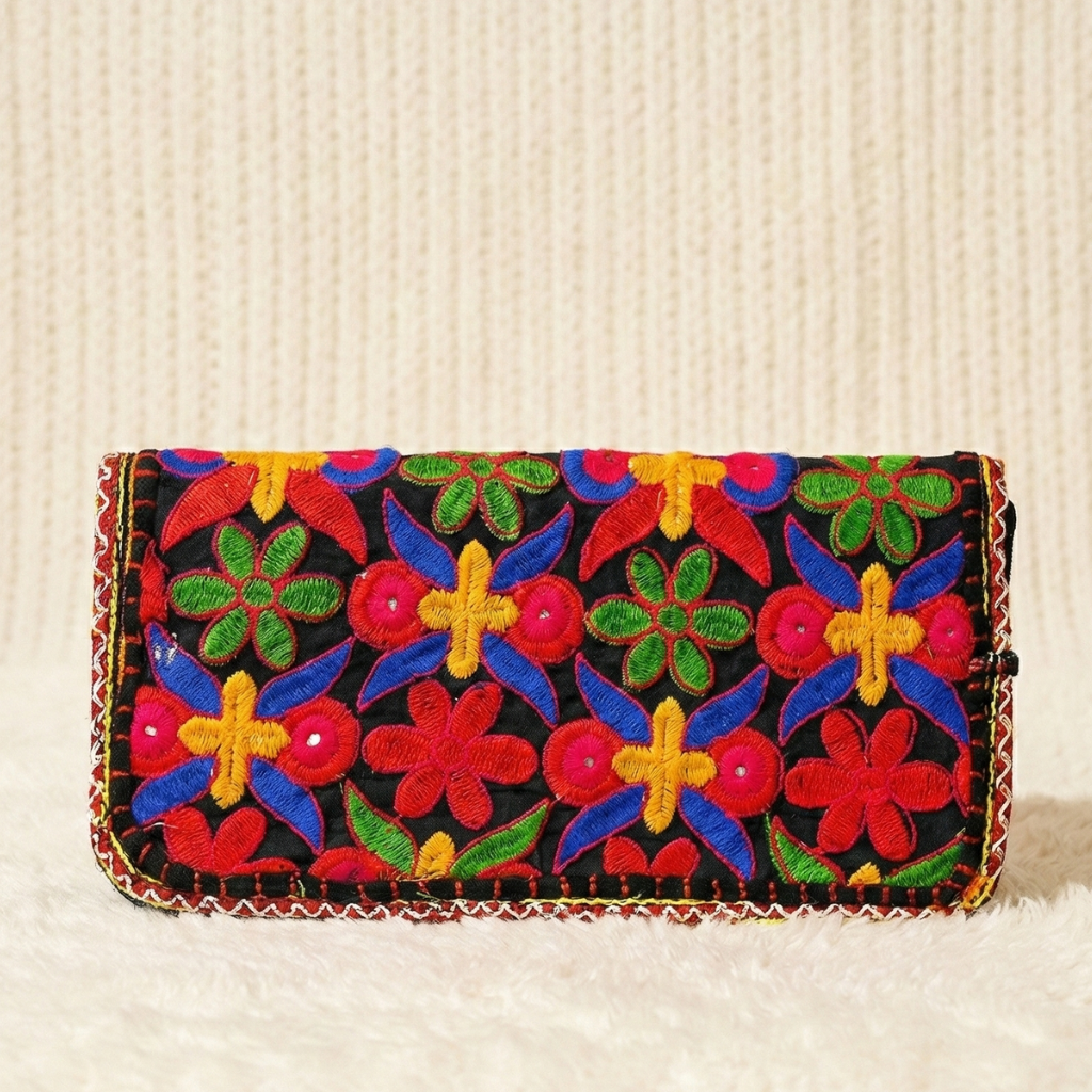 Colorful embroidered clutch bag on a textured beige background