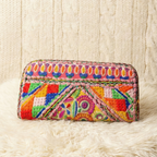 Colorful embroidered clutch bag on a textured white surface
