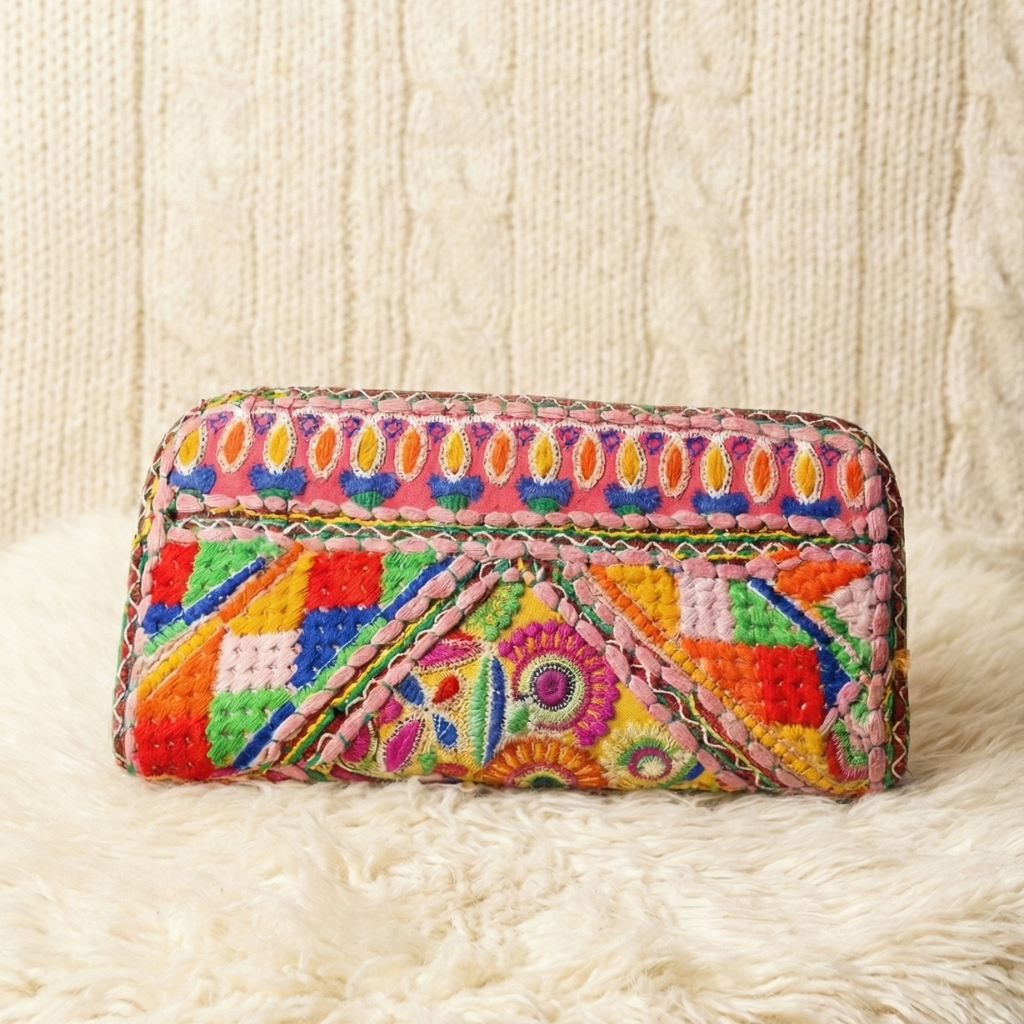 Colorful embroidered clutch bag on a textured white surface