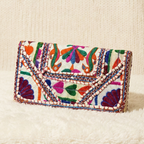 Colorful embroidered clutch bag on a textured surface