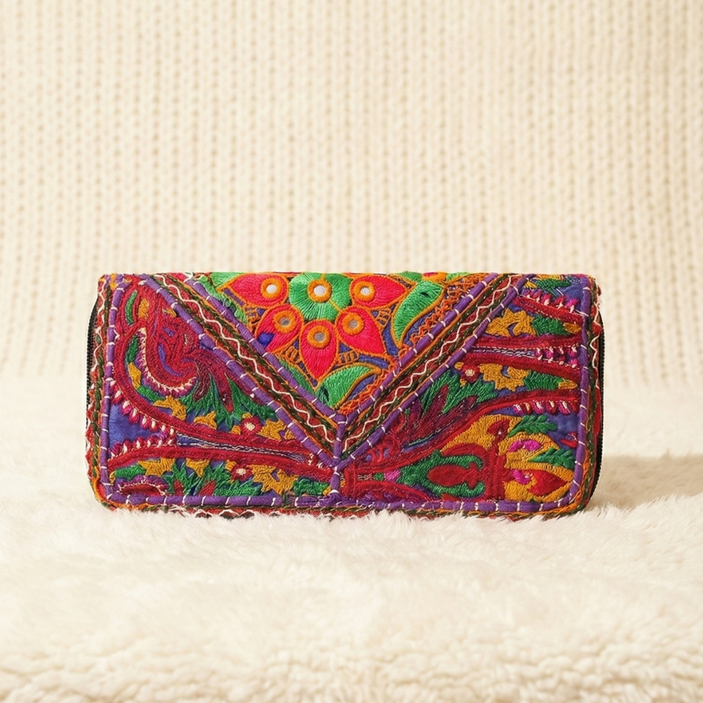 Colorful embroidered clutch bag on a textured beige surface