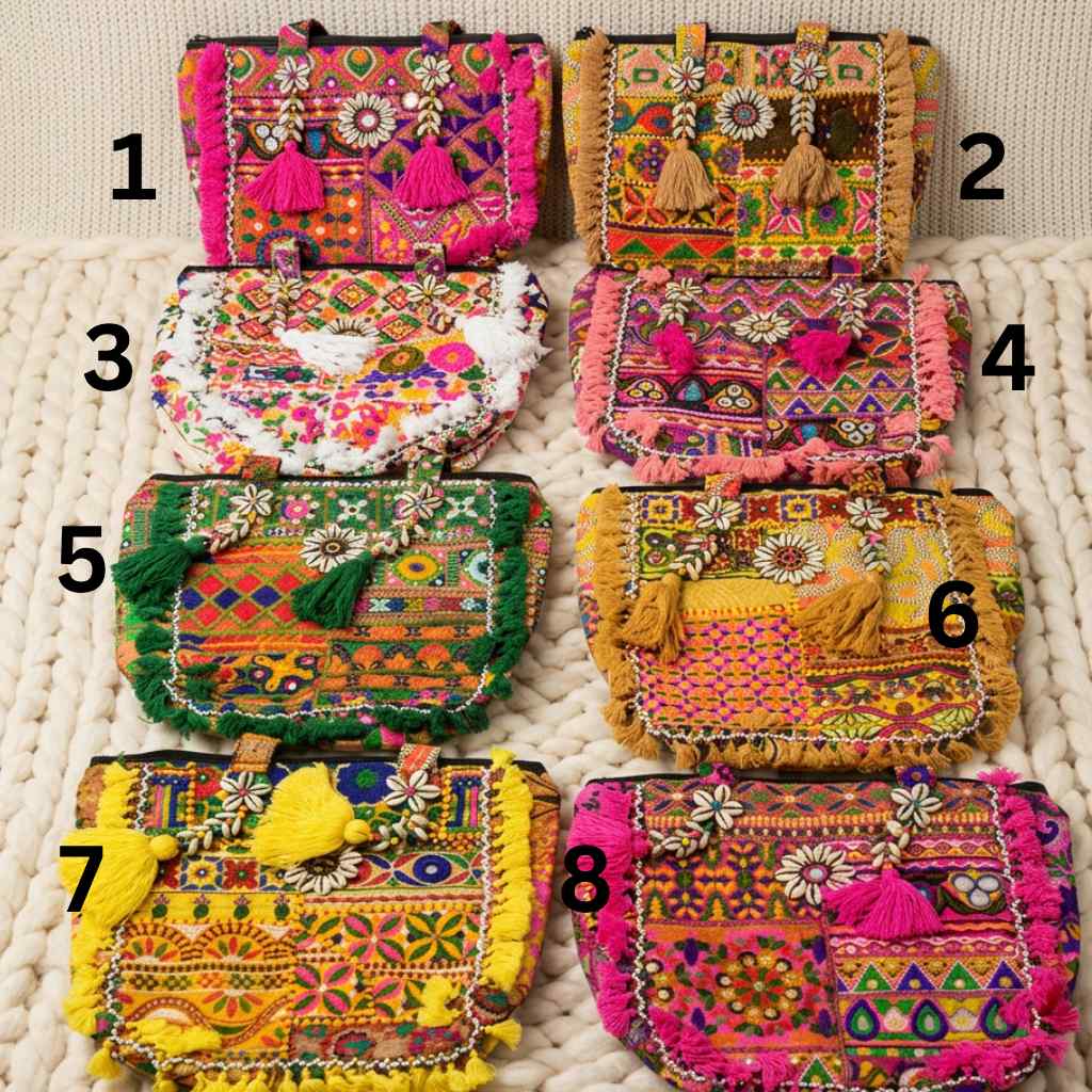 Eight colorful embroidered banjara tote bags on a textured surface