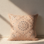 Decorative cushion cover with intricate patterns on a neutral background
