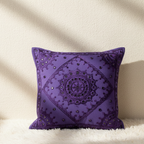 Purple decorative cushion cover with intricate patterns on a beige background