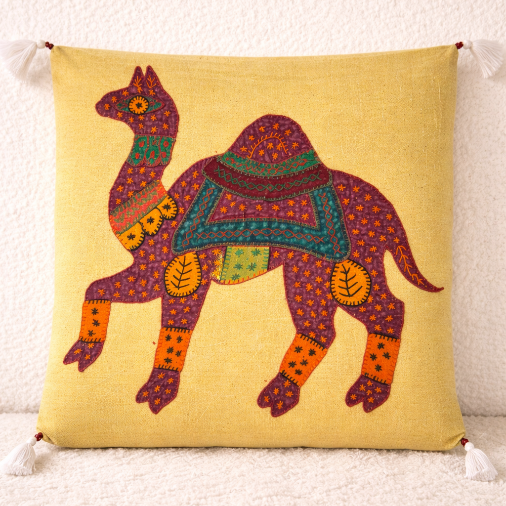 Decorative applique cushion cover with a colorful camel design on a yellow background