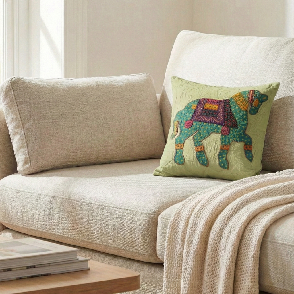 Beige sofa with a pastel green cushion cover featuring an embroidered camel design.