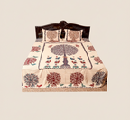 Decorative bedspread with tree of life design on a bed 