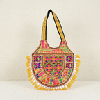 Colorful embroidered shoulder bag with tassels on a beige background