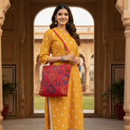 Woman in a yellow dress holding a red bag in front of an architectural background