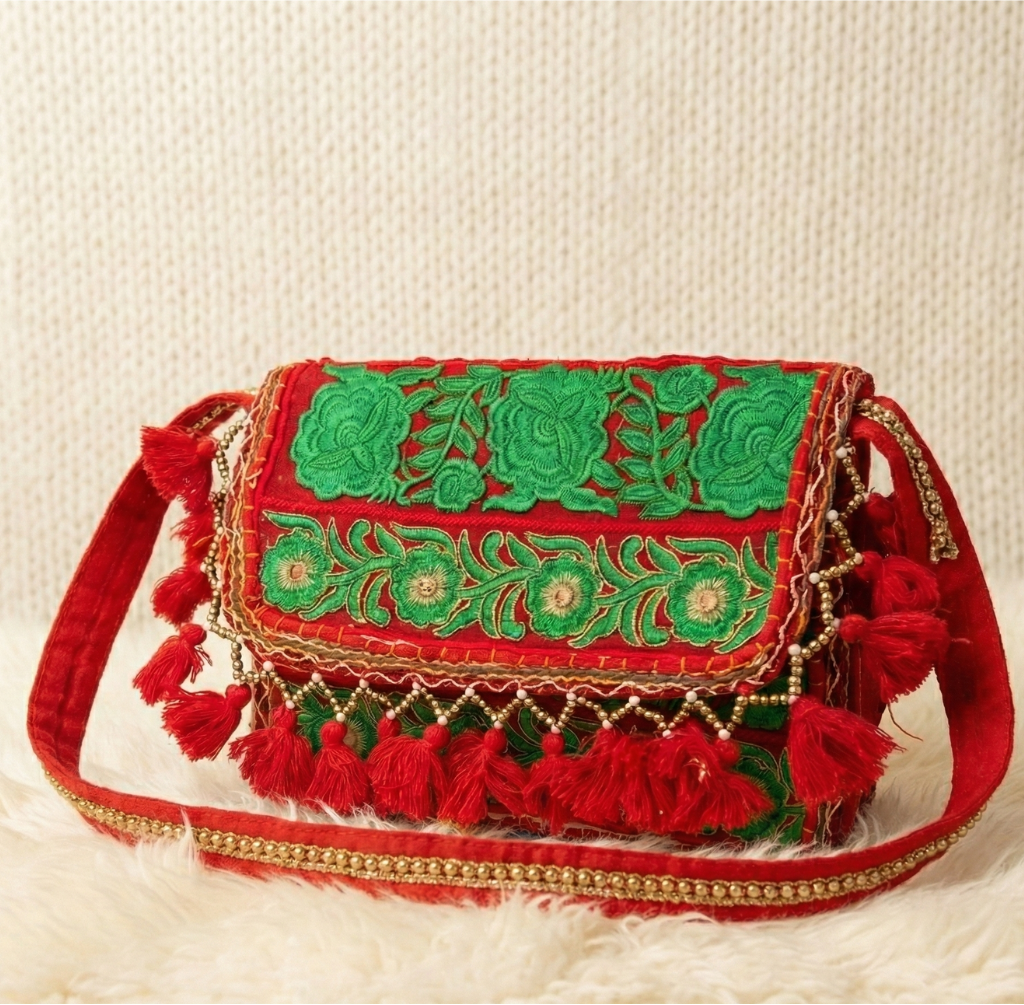 red banjara sling bag with green embroidery and tassels