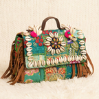 Colorful banjara handbag with shell embellishments on a textured surface