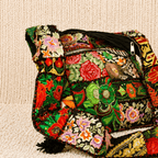 Colorful embroidered bag on a beige textured surface