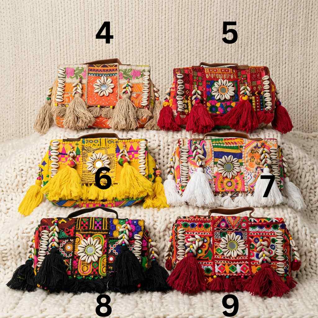 Colorful embroidered banjara handbags with tassels on a textured surface