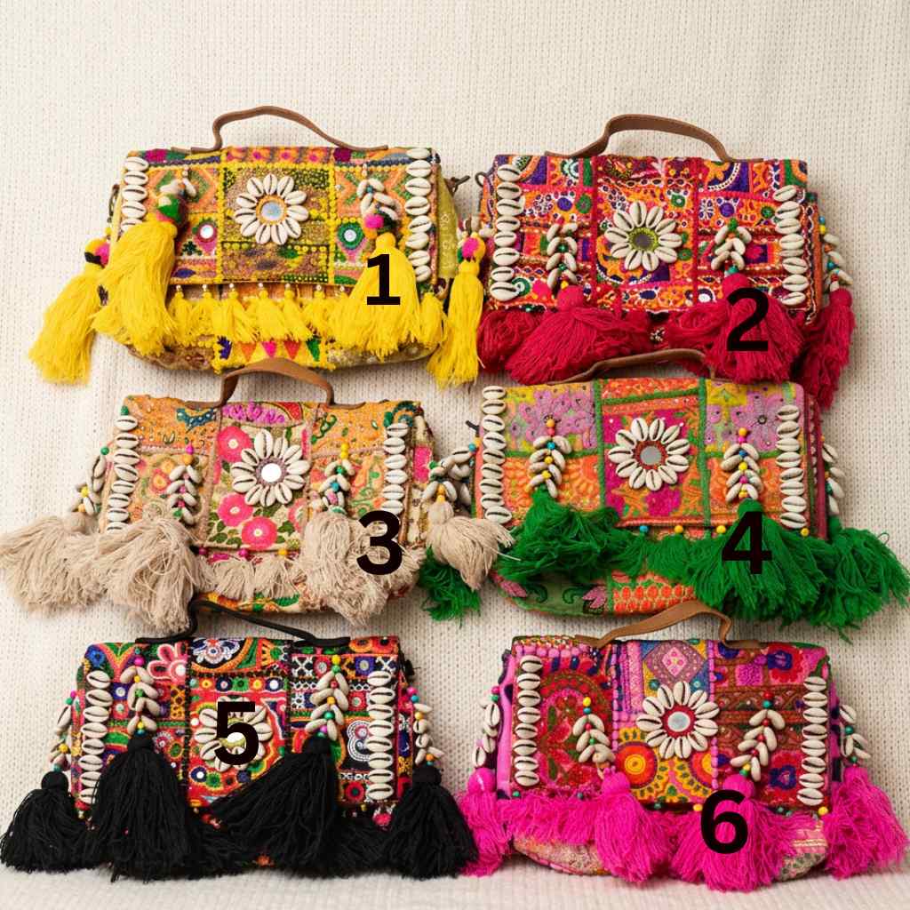 Colorful banjara bags with floral patterns and tassels on a light background