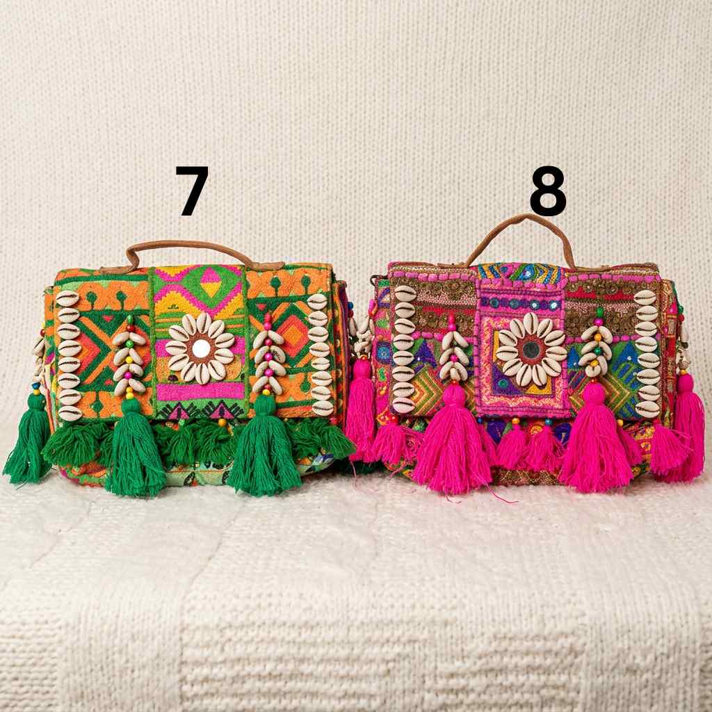 Two colorful handbags with tassels on a textured surface