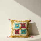 Decorative applique cushion cover with colorful patterns on a white background