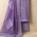 Purple fabric with white floral patterns and geometric designs on a beige background