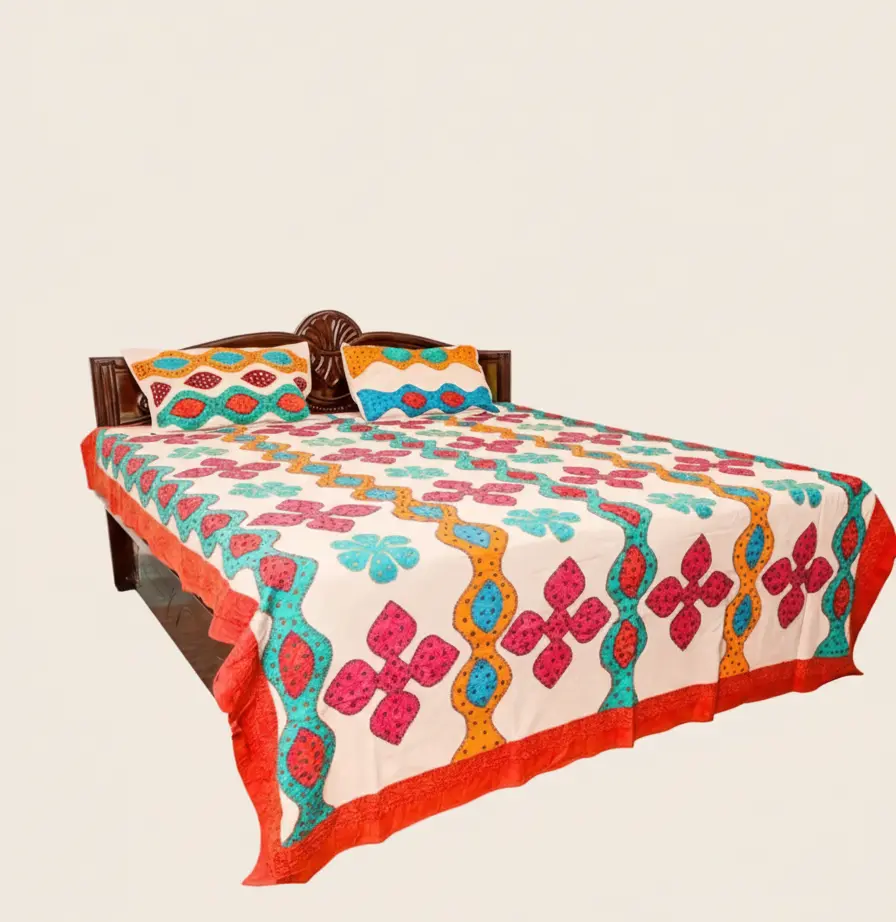 Colorful floral applique bedsheet with geometric pattern on a bed against a beige background
