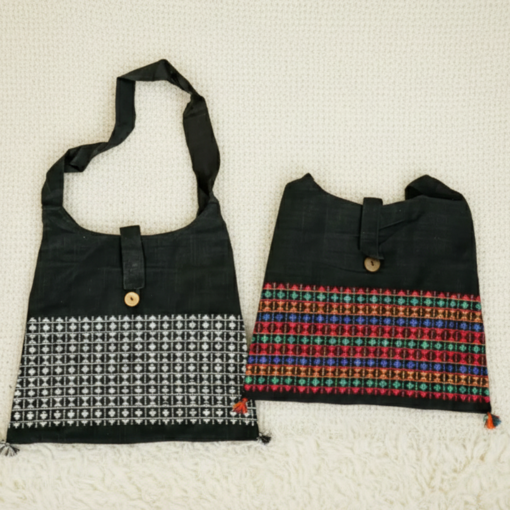 Two black bags with patterned designs on a beige textured background