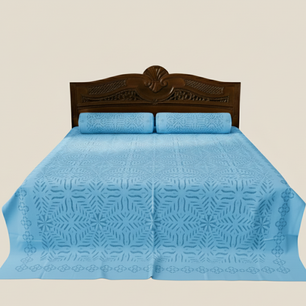 Blue patterned bedspread on a bed with a wooden headboard against a beige background