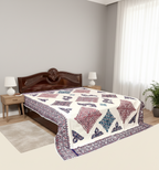 Bed with a patterned bedsheet in a bedroom setting