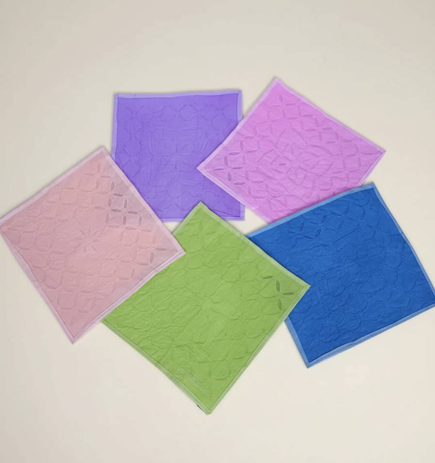 Five colorful napkins on a light beige background