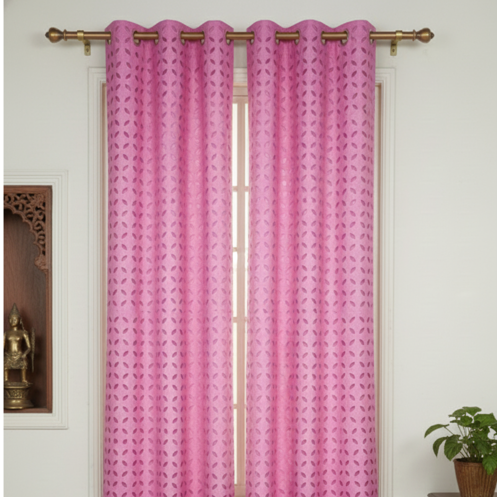 Pink curtains with a geometric pattern hanging in front of a window.