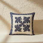 applique cushion cover with blue floral patterns on a beige background