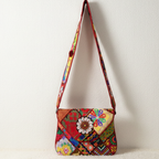 Colorful patterned handbag with a floral design on a white background